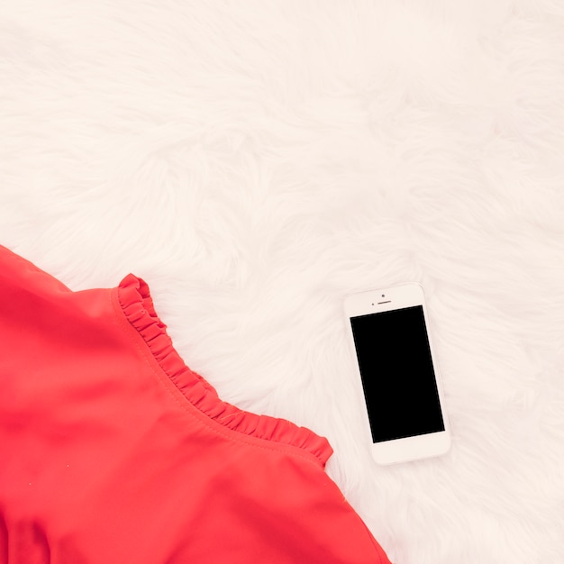 Smartphone met rode rok op deken