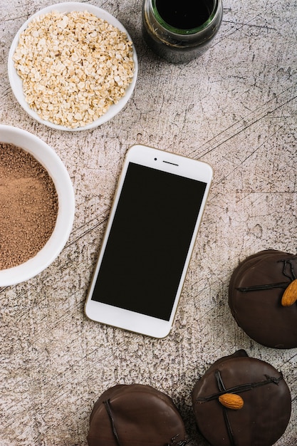 Gratis foto smartphone tussen koekjes en likdoorns