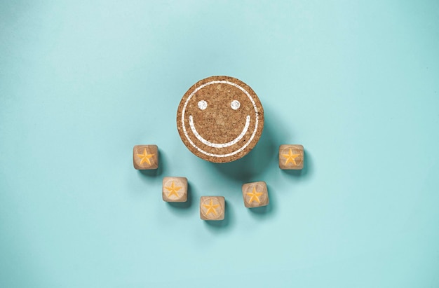 Smile face printscreen op rond houten blok met gouden vijf sterren voor klanttevredenheid na gebruik product- en serviceconcept