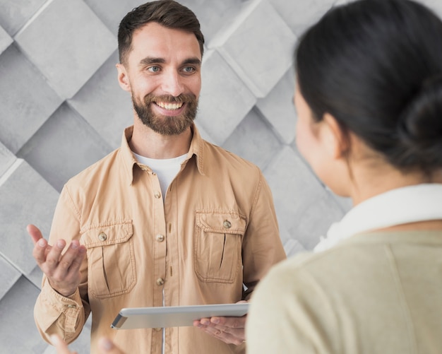 Smiley bebaarde man bespreken met zijn collega