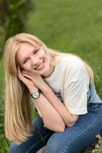 Smiley en gelukkige vrouw poseren in de natuur