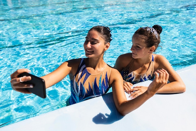Smiley jong meisje dat een selfie neemt bij het zwembad