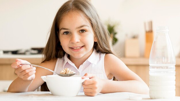 Smiley jong meisje granen eten voor het ontbijt