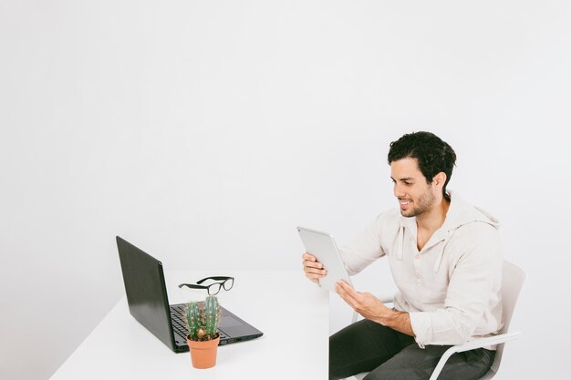 Smiley jonge man met tablet op het werk