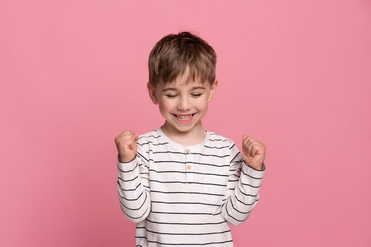 Gratis Foto smiley jongetje geïsoleerd op roze