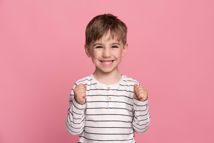 Gratis Foto smiley jongetje geïsoleerd op roze