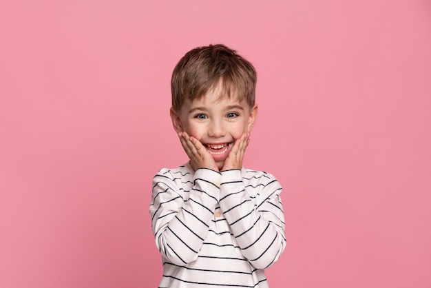 Gratis foto smiley jongetje geïsoleerd op roze