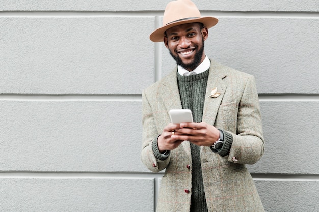 Smiley knappe man kijkt naar zijn telefoon