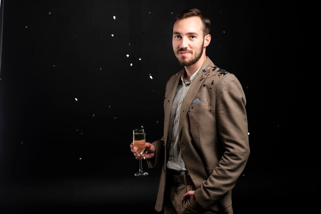 Smiley man bedekt met confetti champagne glas te houden