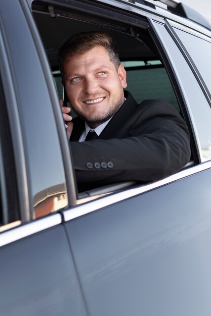 Smiley man praten aan de telefoon in de auto