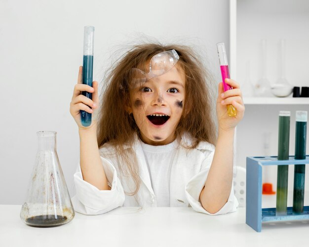 Smiley meisje wetenschapper in het laboratorium met reageerbuizen en mislukt experiment