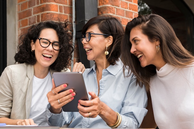 Smiley moderne vrouwen die op een tablet kijken