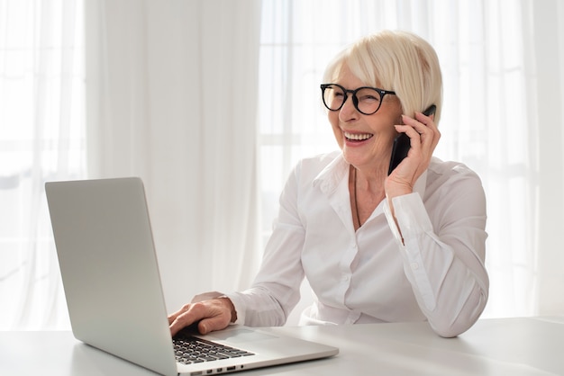 Smiley oude vrouw praten aan de telefoon