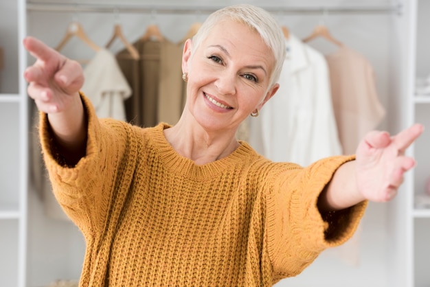 Gratis foto smiley volwassen vrouw poseren met open armen