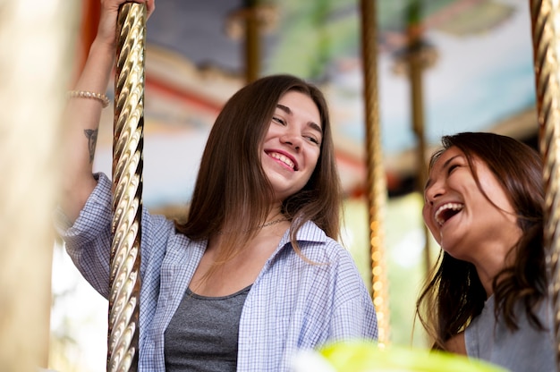 Gratis foto smiley-vriendinnen op de carrousel