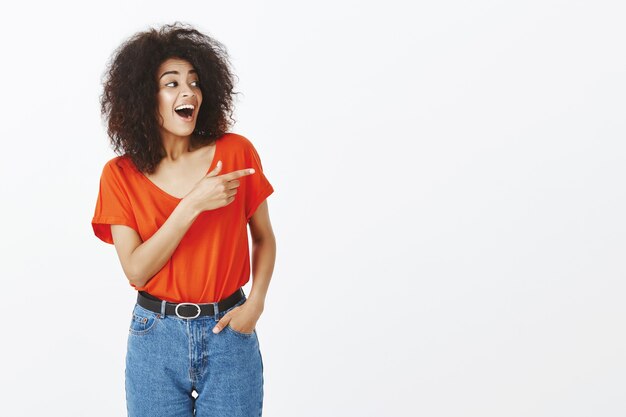 Smiley vrouw met afro kapsel poseren in de studio