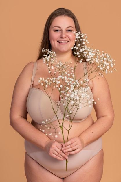 Gratis foto smiley vrouw met bloemen medium shot