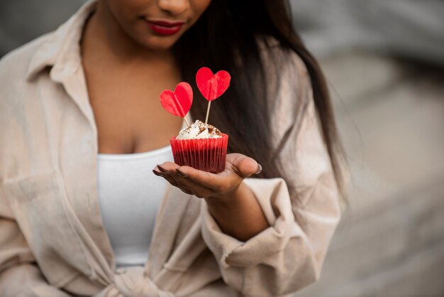 Smiley vrouw met een valentijnsdag cupcake