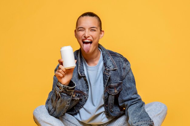 Smiley vrouw met tong uit frisdrankblikje te houden