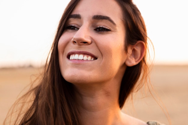 Smiley vrouw poseren buitenshuis bij zonsondergang