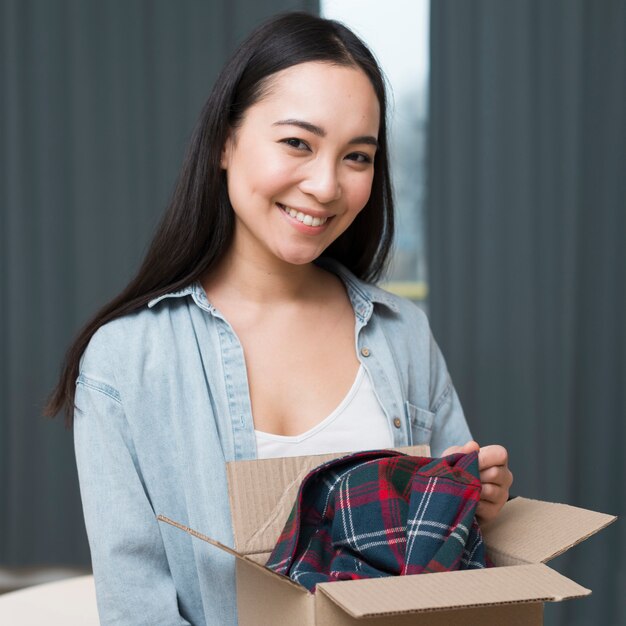 Smiley vrouw poseren met doos die ze online heeft besteld