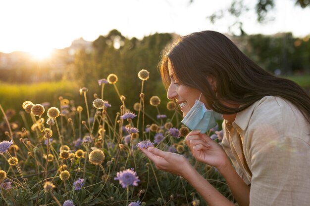 Smiley vrouw ruikende bloemen zijaanzicht