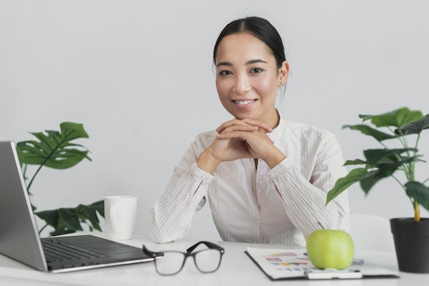 Gratis foto smiley vrouw zitten in het kantoor