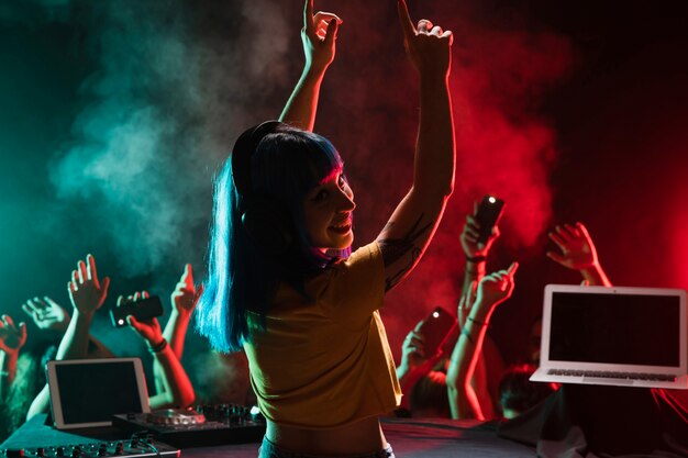 Smiley vrouwelijk DJ dat zich in de club mengt