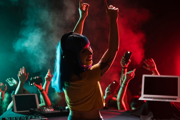 Smiley vrouwelijke dj mixen in de club