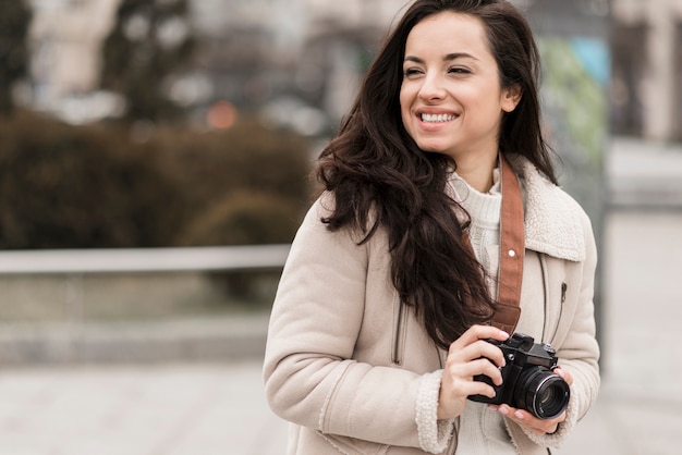 Smiley vrouwelijke fotograaf buitenshuis