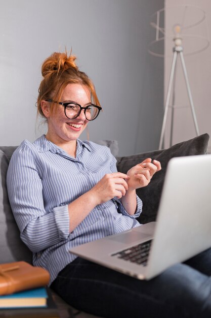 Smiley vrouwelijke leraar die op laag een online klas houdt