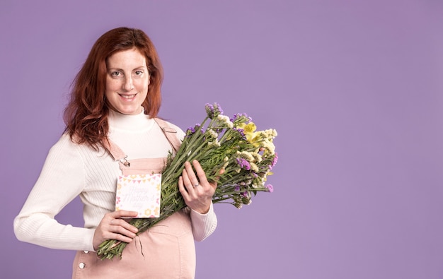 Smiley zwangere vrouw met bloemen boeket