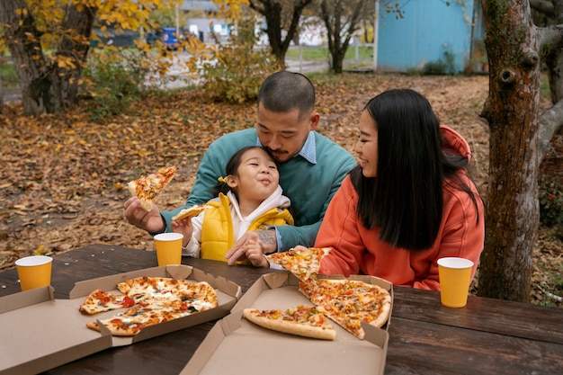 Gratis foto smileyfamilie met heerlijk pizza vooraanzicht