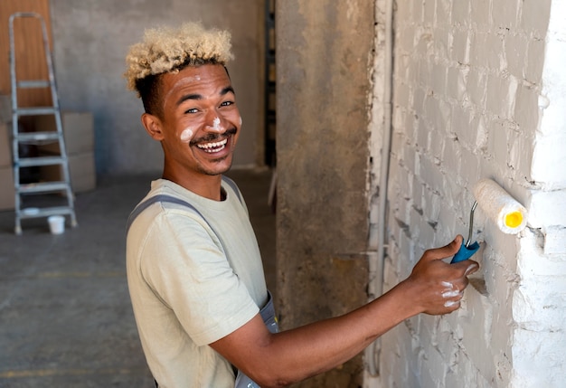 Smileyman die de muren van zijn nieuwe huis schildert