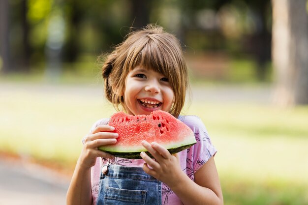 Smileymeisje die van watermeloen genieten