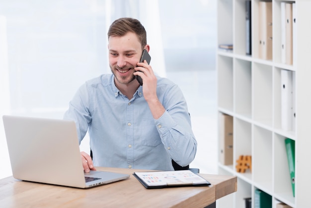 Gratis foto smileymens die aan laptop werkt