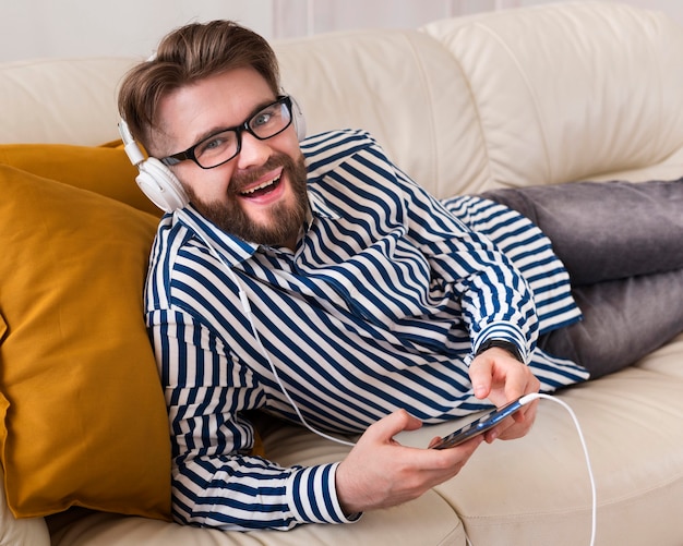 Gratis foto smileymens die aan muziek op hoofdtelefoons luisteren