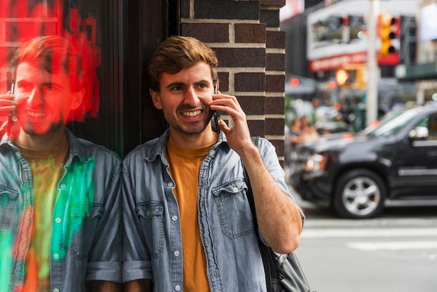 Gratis foto smileymens die bij telefoon in stad spreken