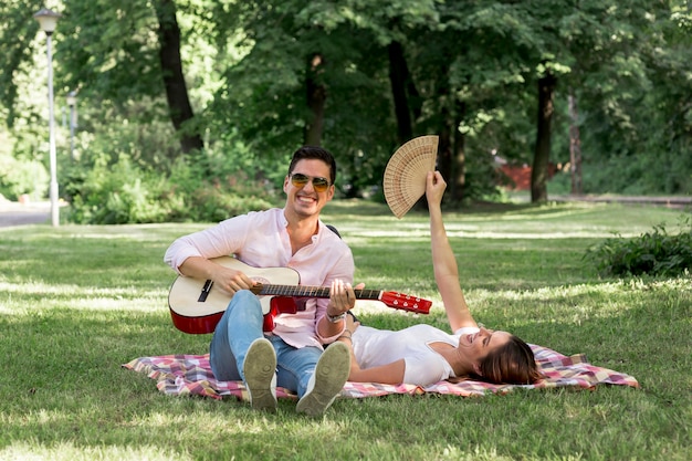 Smileymens die de gitaar in park speelt