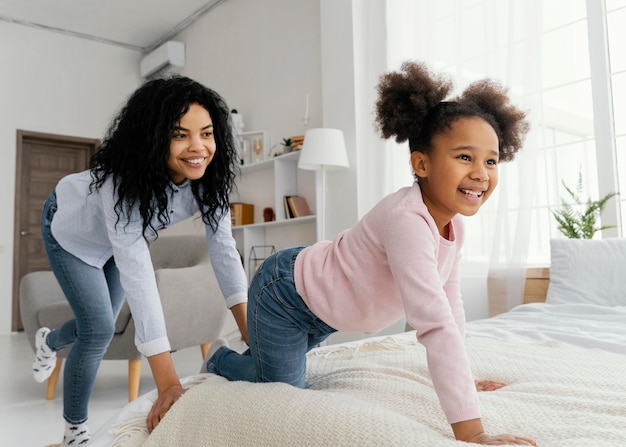 Smileymoeder die thuis met haar dochter speelt