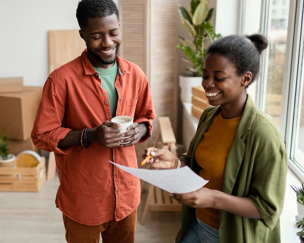 Gratis foto smileypaar dat bij het opknappen van huis van plan is