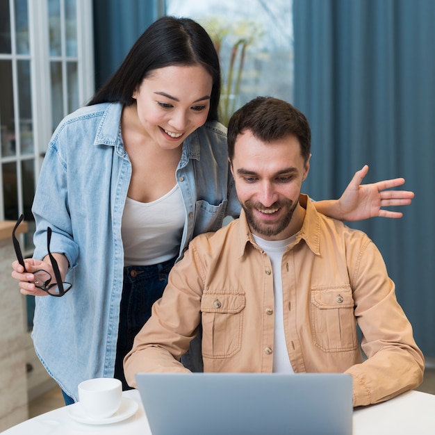 Gratis foto smileypaar die online op laptop winkelen