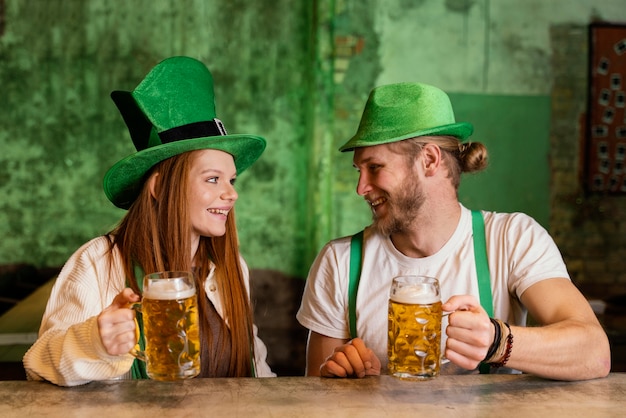 Gratis foto smileypaar vieren st. patrick's day aan de bar