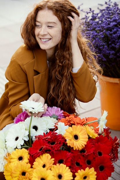 Smileyvrouw buiten in het voorjaar met een boeket bloemen