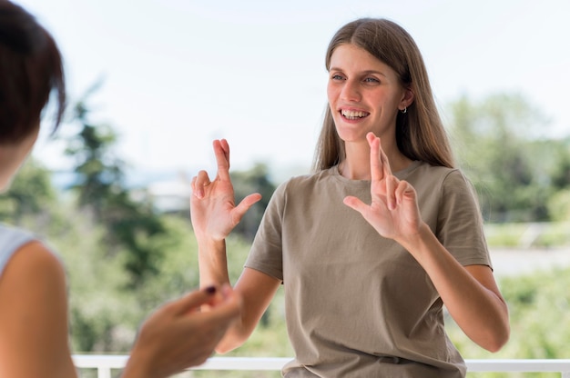 Smileyvrouw communiceren via gebarentaal terwijl buitenshuis