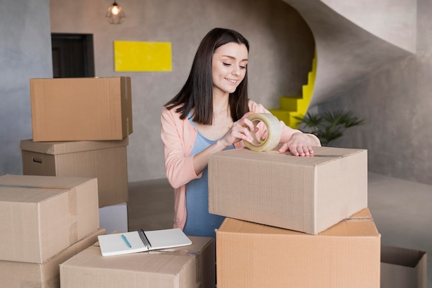 Smileyvrouw die dozen voor verzending voorbereiden