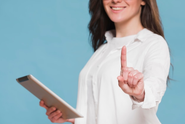 Smileyvrouw die een digitale tablet houden