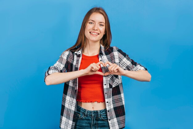 Smileyvrouw die een hart met haar handen maakt