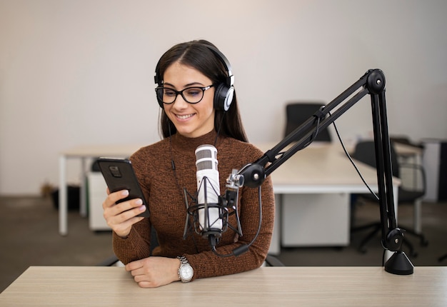 Gratis foto smileyvrouw die een radioshow doet