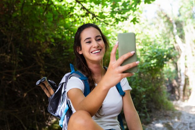 Smileyvrouw die een selfie neemt tijdens het verkennen van de natuur